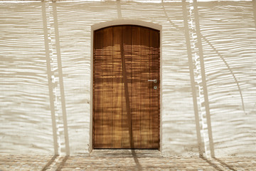 Wood door in a typical mediterranean house in a sunny day with a stone floor