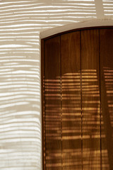 Detail of a wood door in a typical mediterranean house with shadows