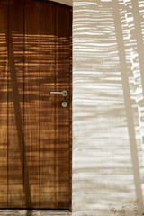 Detail of a wood door in a typical mediterranean house with shadows