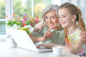 Obraz na płótnie Canvas Girl with grandmother using tablet