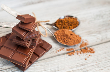 Chocolate, cocoa and nuts on a light, wooden background. Close-up with place for text