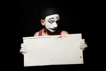 Sad mime holding white paper dirty sheet in hands