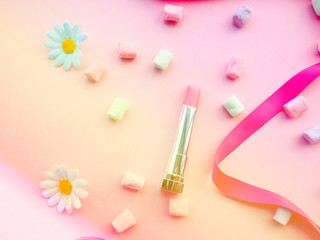 Fashion concept : Flat lay of pink cute woman bag lipstick, creams, honey, marshmallow, powder on colorful background with copy space