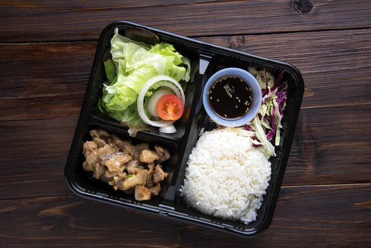Freshly served bento box  on wooden table background. top view