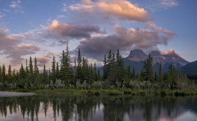 Three Sisters at sunset along the Bow River in Alberta Canada