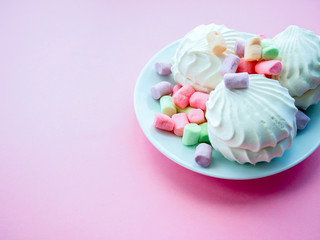 Marshmallow in white plate on pink background