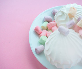 Marshmallow in white plate on pink background
