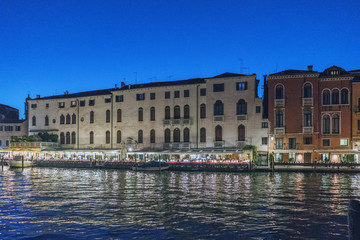  Night view of people dining at a restaurant on the shore of the Grand Canal in Venice, Italy