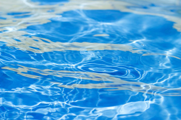 Background of clean water in a blue swimming pool