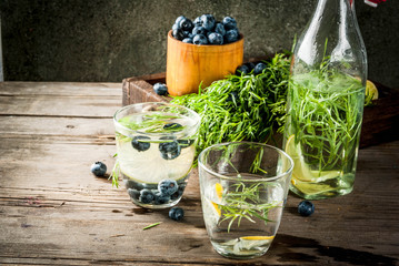 Summer refreshment diet drinks. Infused detox waters in different glasses nd bottles with rosemary,...