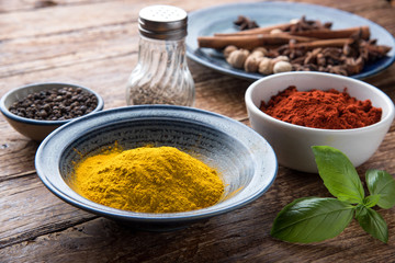 turmeric powder with spices on wooden background. asian food, healthy or cooking concept.