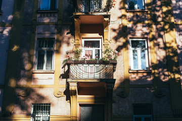 Traditional European residential house with balconys with colorful flowers and flowerpots.