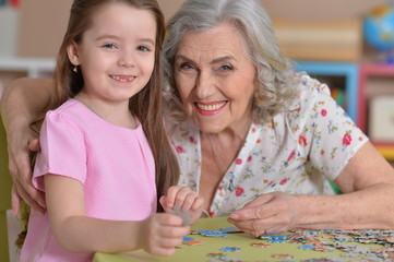 Fototapeta premium Grandmother collecting puzzle