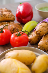 Pepper, potato, kaiser bun and baguette on wood table. Vegetarian bio food concept.