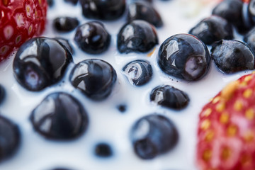 Strawberries, blueberries and milk in a white bowl