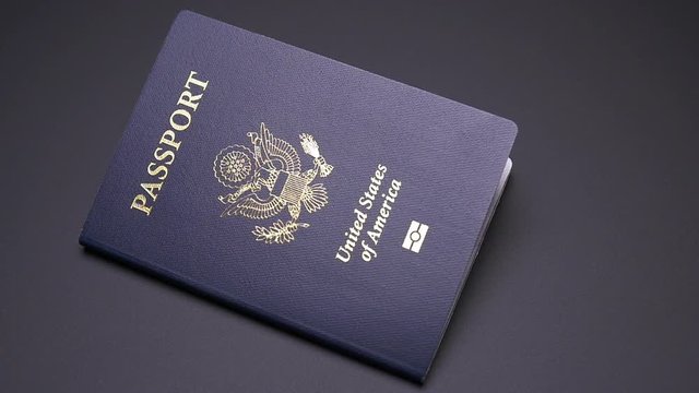 SINGLE UNITED STATES PASSPORT DROPS INTO FRAME IN SLOW MOTION