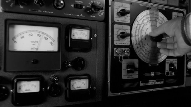 RADIO OPERATOR ADJUSTS VINTAGE EQUIPMENT