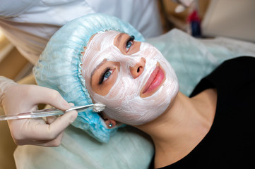 Cosmetologist makes the mask beautiful girl