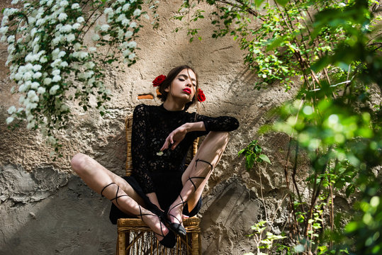 Girl With Flower In Mouth Sitting On Chair