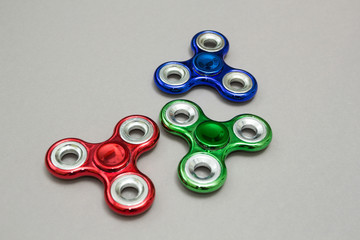 Group fidget spinner stress relieving toy on grey background.