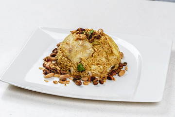 Traditional Middle Eastern fish and fried rice dish with fried pine nuts
