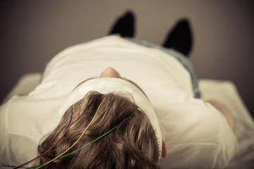 Patient Lying on Table with Head Bandage and Wires
