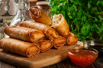 Spring rolls with chicken and vegetables on chopping board
