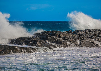 Waves breaking at rocks of the Indian Ocean at the Wild Coast of South Africa with cloudy sky