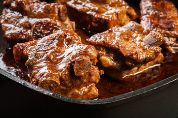 Pork spare ribs on dish in own sauce