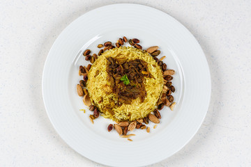 Traditional Middle Eastern fish and fried rice dish with fried pine nuts