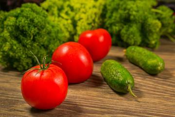 Tomatoes and cucumbers on an old wooden table. The concept of a healthy diet