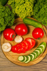 Fresh vegetables. Tomatoes, cucumbers and mushrooms on a wooden board