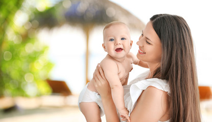 Mother holding little baby indoors