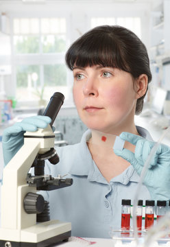 Portrait of a young female scientist working with microscope