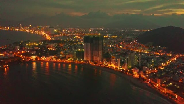 Flycam Moves to Skyscraper in Ocean Resort City at Night