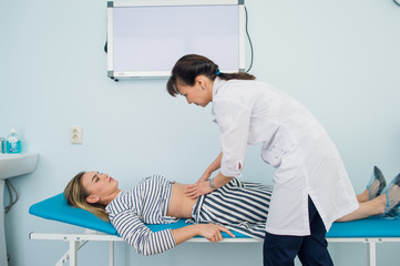 Doctor checking the stomach of one of her patients
