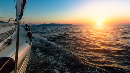 Fototapeta premium Sunset from the deck of the sailing boat moving in a sea.
