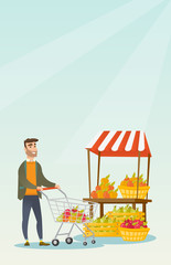 Naklejka premium Young caucasian man pushing a supermarket cart.