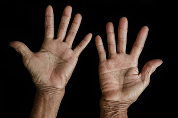 Fototapeta premium The old woman's hands on black background