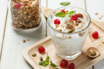 Homemade yogurt or sour cream in a glass on the white wooden table