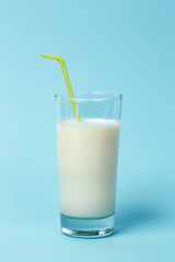 Fresh glass of milk with Straw, on blue background