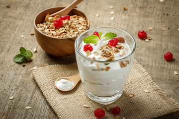 Homemade yogurt or sour cream in a glass on the wooden table