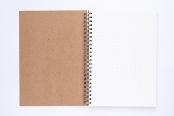 Top view of opening  spiral notebook with dotted-pattern pages on the white background.