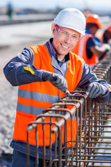 worker fixing steel rebar at building site
