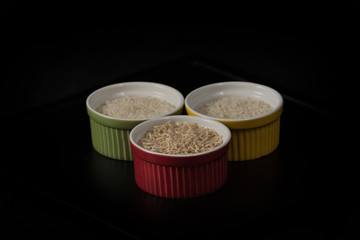 Shades of Rice. Different rices in colored ramekins