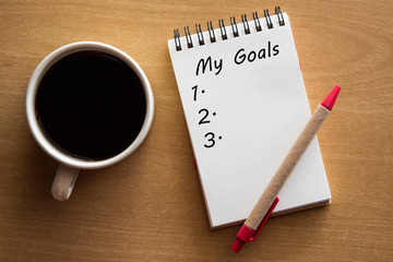 My goals list - handwriting on a notebook with cup of coffee