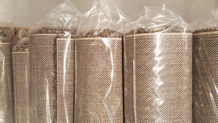 Top view of brown fabric roll wrapped in plastic roll bag / stock of brown fabric for fashion design business, raw material in garment manufacturing