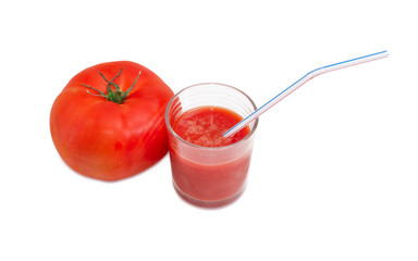 Tomato and glass of tomato juice with drinking straw