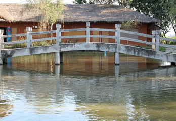 Fototapeta na wymiar The old concrete footbridge across the pond.