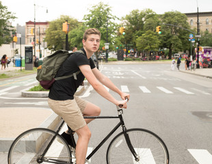 College student riding bike crossing the crosswalk in the city